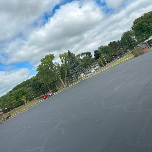 Freshly sealcoated public park parking lot in Portage, Wisconsin, completed by Cimaroli Sealcoating, featuring smooth and durable asphalt.
